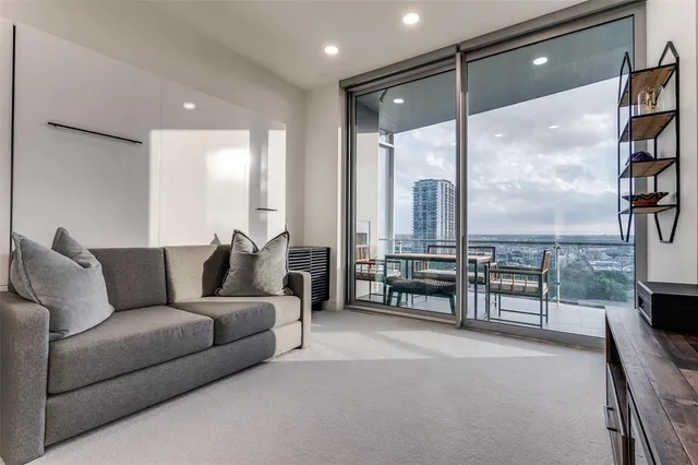 a living room with furniture and a floor to ceiling window
