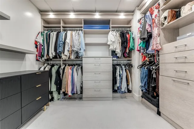 a view of walk in closet with clothes and shoes