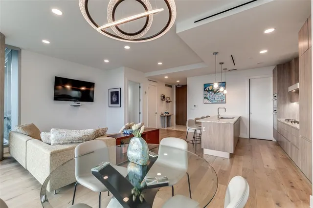 a living room with furniture a flat screen tv and kitchen view