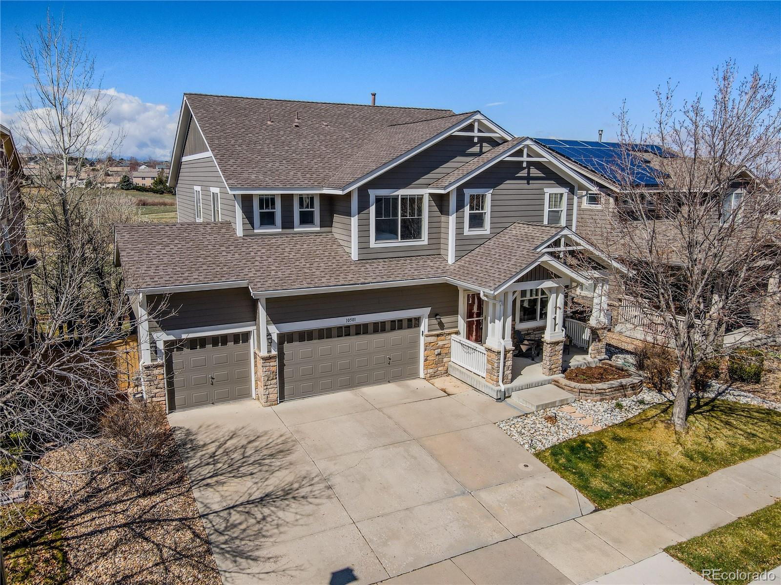 a view of a house with a yard and large tree