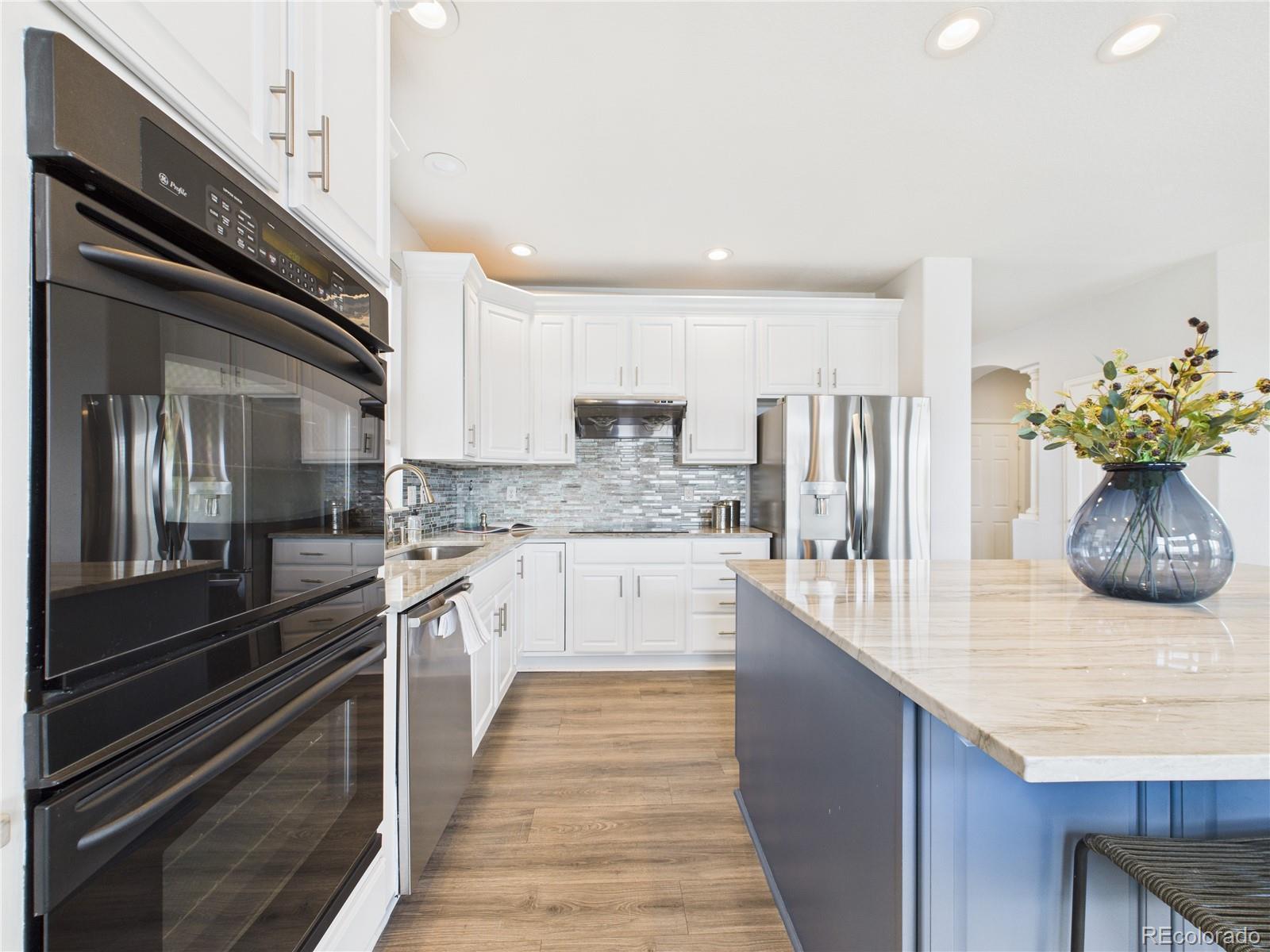 10501 Wagon Highlands Ranch Highlands Ranch, CO 80130 - Photo 14 of 50 a kitchen with stainless steel appliances granite countertop a refrigerator a stove and a sink