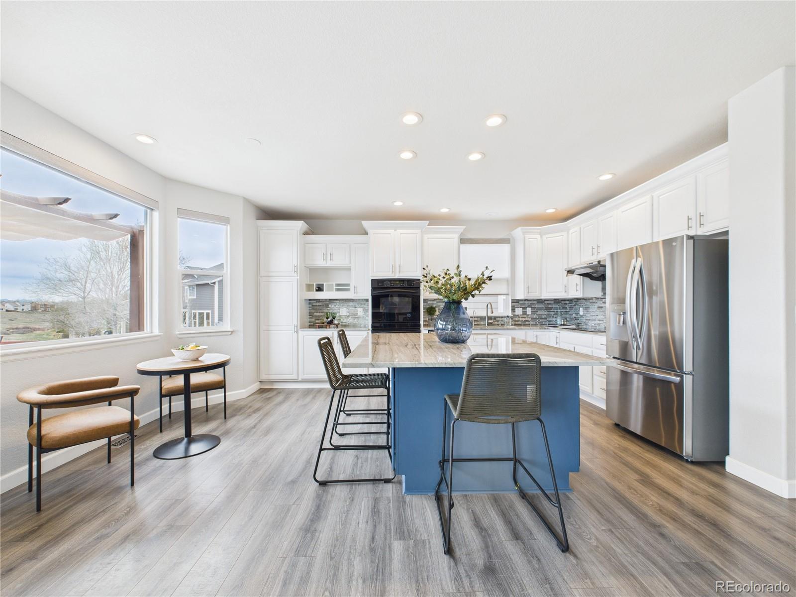 10501 Wagon Highlands Ranch Highlands Ranch, CO 80130 - Photo 15 of 50 a kitchen with stainless steel appliances a dining table chairs refrigerator and sink