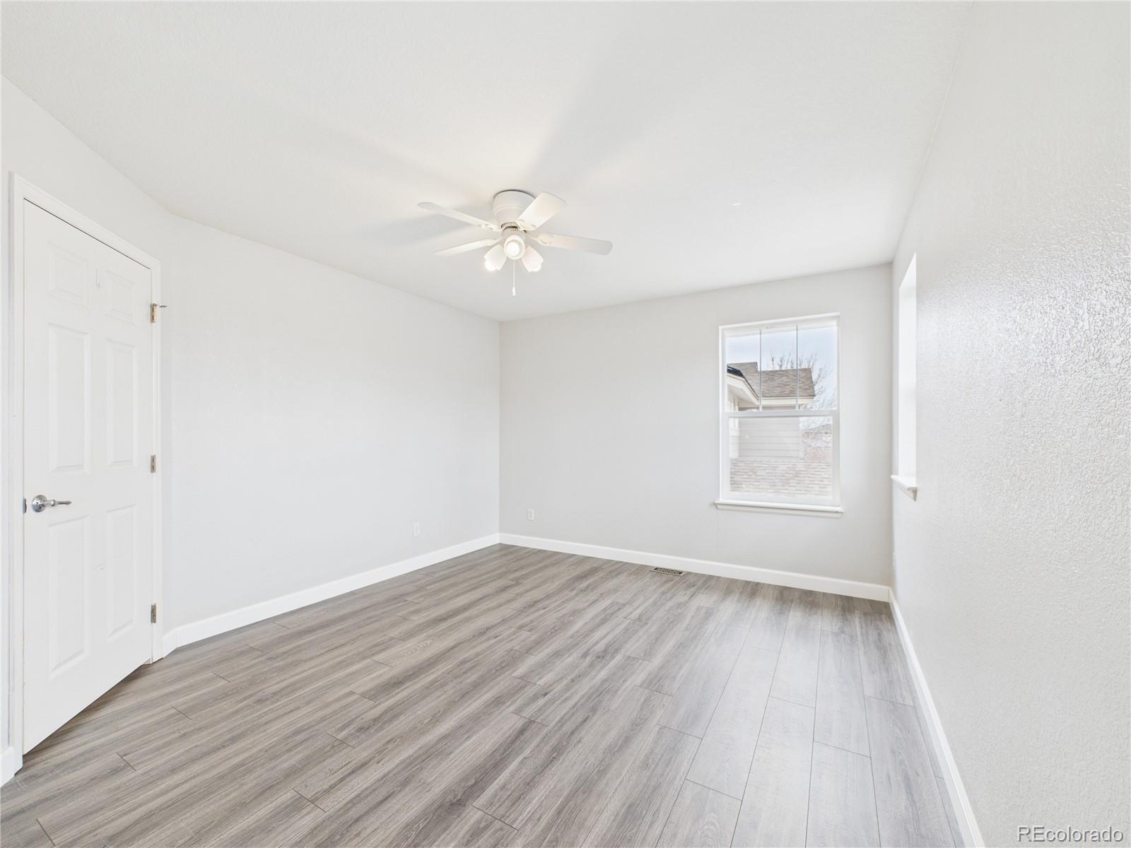 10501 Wagon Highlands Ranch Highlands Ranch, CO 80130 - Photo 19 of 50 an empty room with wooden floor and windows