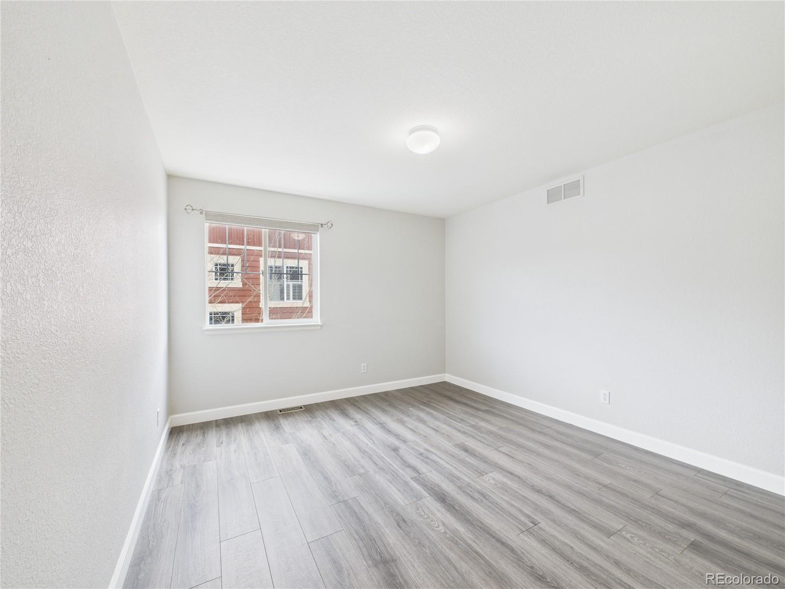 10501 Wagon Highlands Ranch Highlands Ranch, CO 80130 - Photo 22 of 50 an empty room with wooden floor and windows