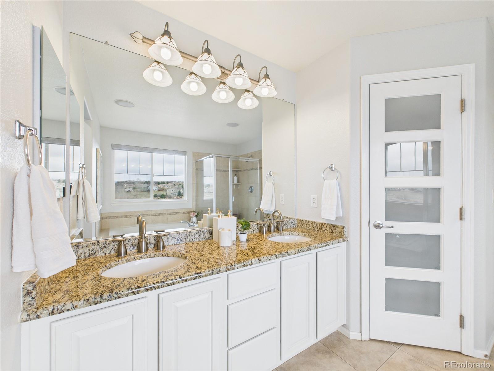 10501 Wagon Highlands Ranch Highlands Ranch, CO 80130 - Photo 28 of 50 a bathroom with a granite countertop sink and a mirror