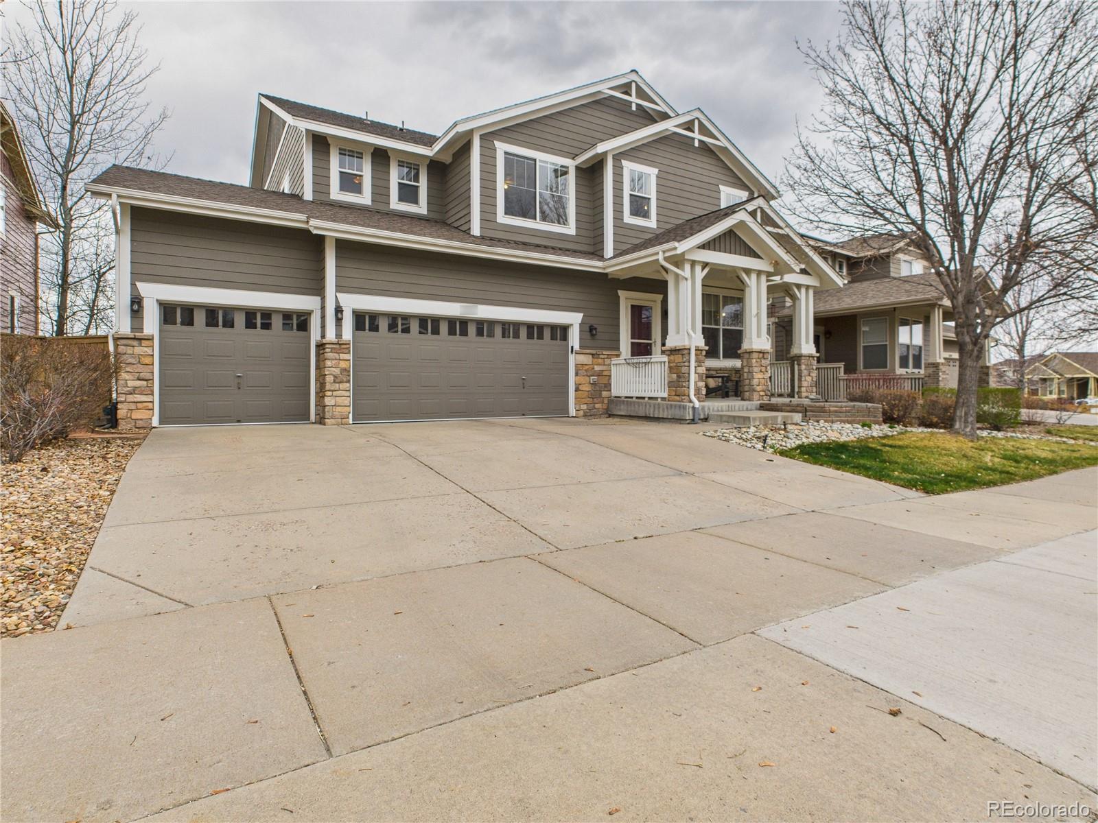 10501 Wagon Highlands Ranch Highlands Ranch, CO 80130 - Photo 3 of 50 a view of a white house with large windows and a small yard