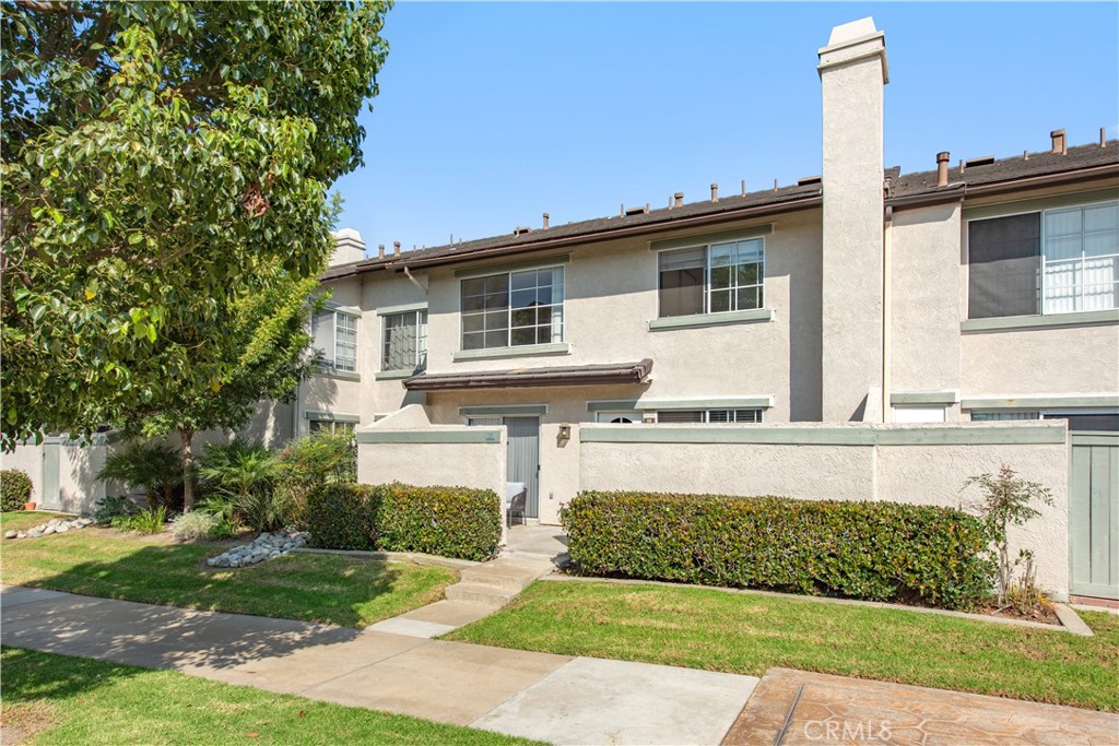 28 Exeter, Unit 19 Irvine, CA 92612 - Photo 2 of 35 a front view of a house with a garden and yard