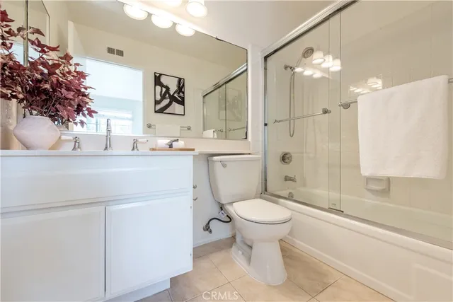a bathroom with a sink toilet vanity and shower