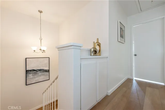 a room with painting on the wall and a wooden floor
