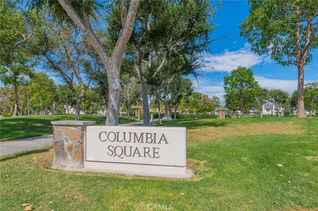 a sign of golf club on a wall under a tree