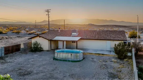an aerial view of ocean and residential houses with outdoor space