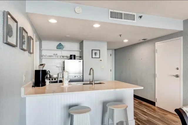 a kitchen with cabinets a sink and chairs