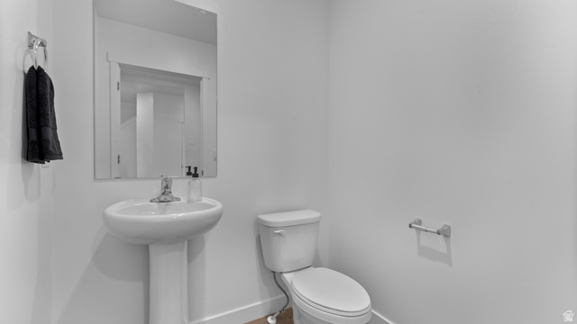 2032 East Dorset Way, Unit 286 Salem, UT 84653 - Photo 3 of 23 Pedestal sink with chrome faucet, a rectangular wall-mounted mirror, and a white toilet