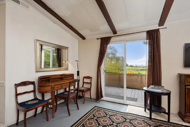 a dining room with furniture and a floor to ceiling window