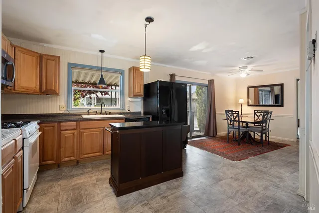 a open kitchen with stainless steel appliances granite countertop a stove and a refrigerator