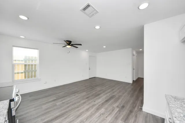 a view of an empty room with wooden floor