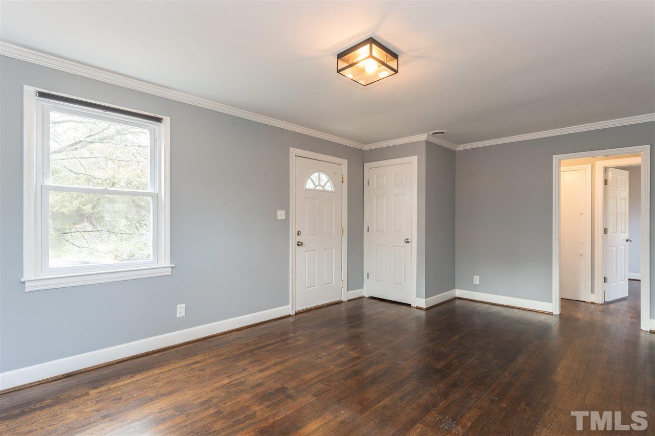 631 Brighton Road Raleigh, NC 27610 - Photo 4 of 25 a view of an empty room with wooden floor and a window