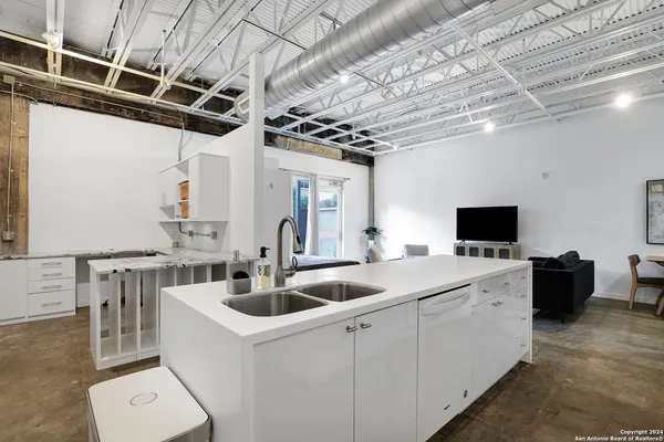 a kitchen that has a sink a stove and a table with chairs