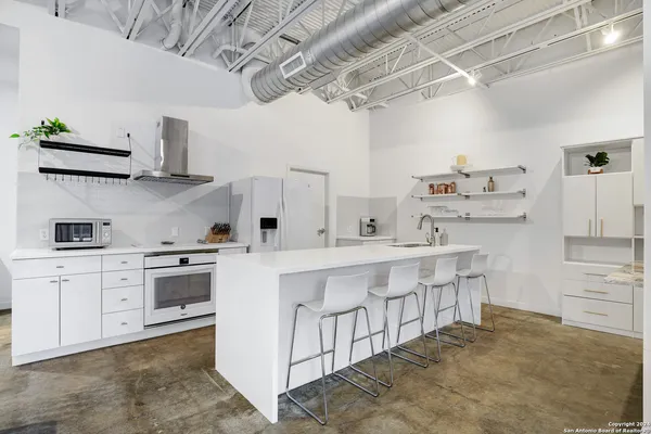 a kitchen with cabinets a sink and white stainless steel appliances