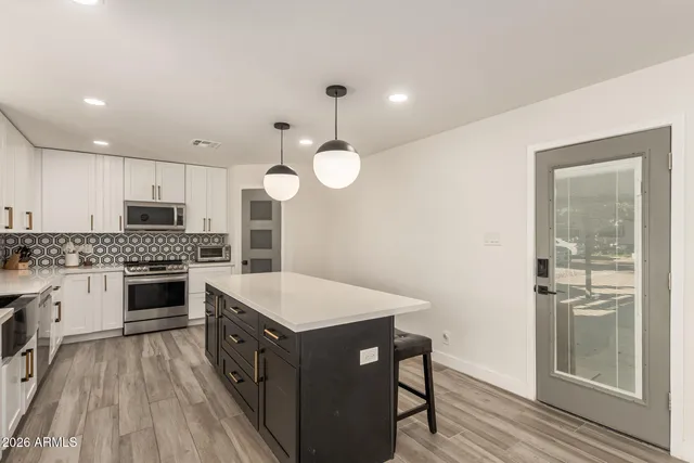 a kitchen with a sink stove top oven and refrigerator