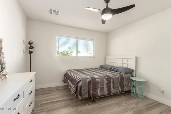 a bedroom with a bed and a chandelier fan