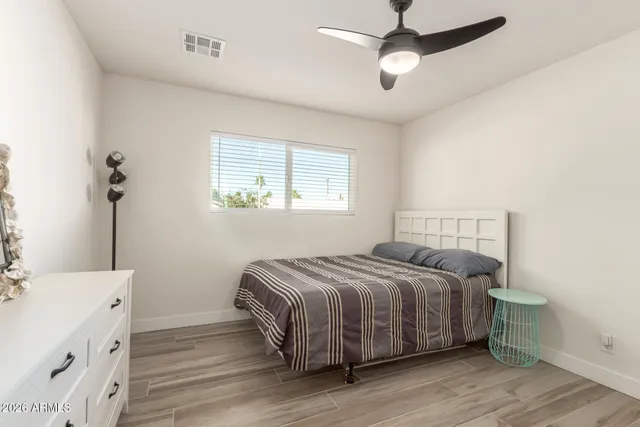 a bedroom with a bed and a chandelier fan