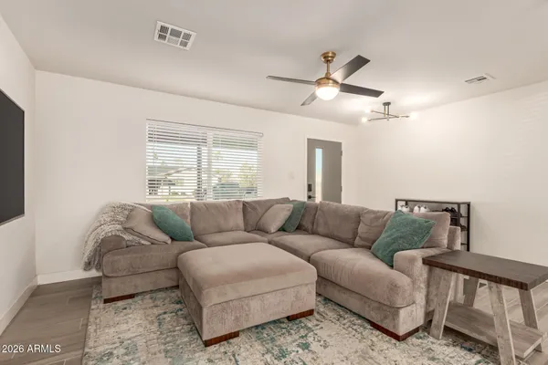 a living room with furniture and a wooden floor