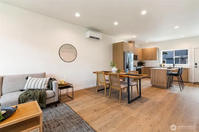 a living room with lots of furniture and a dining table with wooden floor