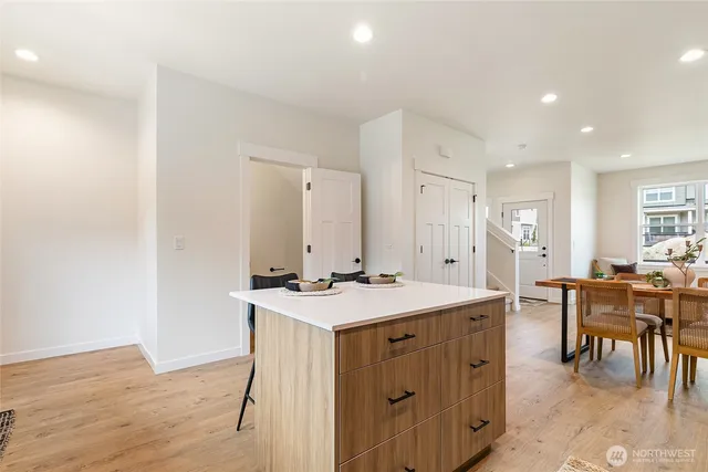 a hall with kitchen island a sink stove and view of living room