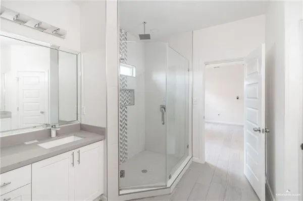 a bathroom with a shower sink and mirror
