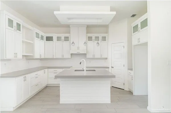 a kitchen with granite countertop a sink and white cabinets