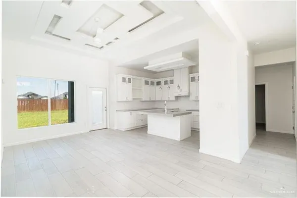 a view of an empty room with a kitchen