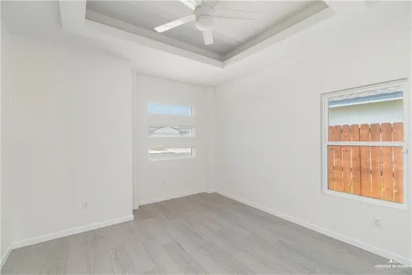 an empty room with a window and wooden floor