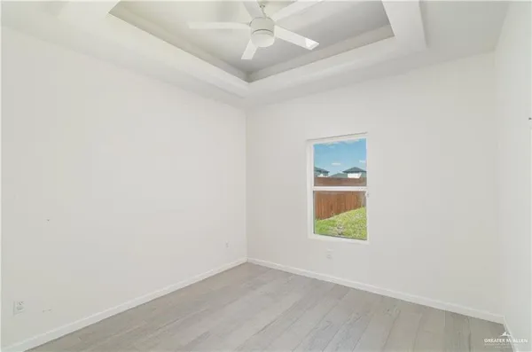 an empty room with a window and wooden floor