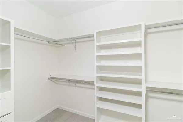 a view of walk in closet with empty racks