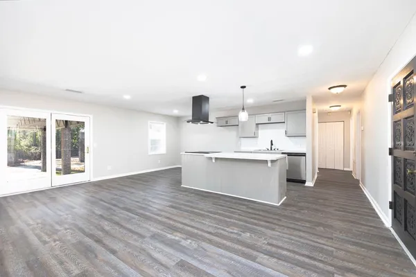 a view of large kitchen with cabinets and wooden floor