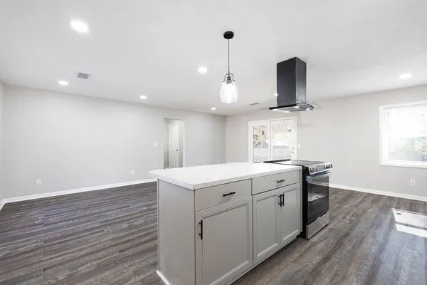a kitchen with a sink stainless steel appliances and wooden floor