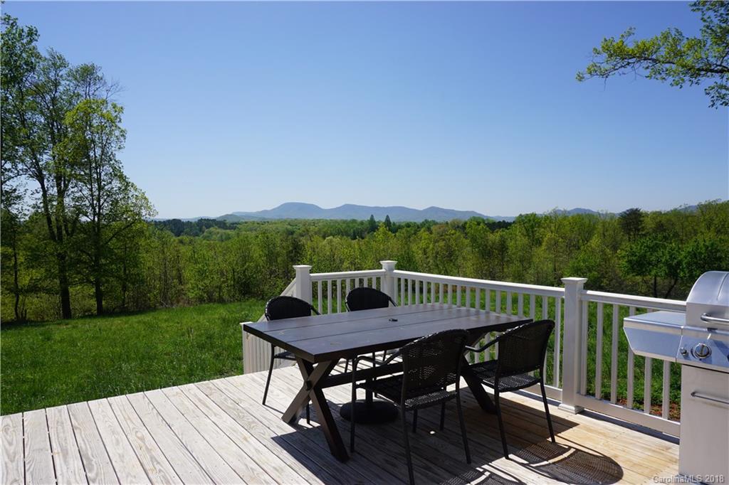 2290 Red Fox Road Tryon, NC 28782 - Photo 22 of 36 a view of a roof deck with table and chairs with wooden floor and fence