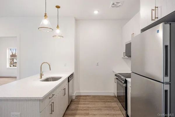 a kitchen with stainless steel appliances a refrigerator sink and stove
