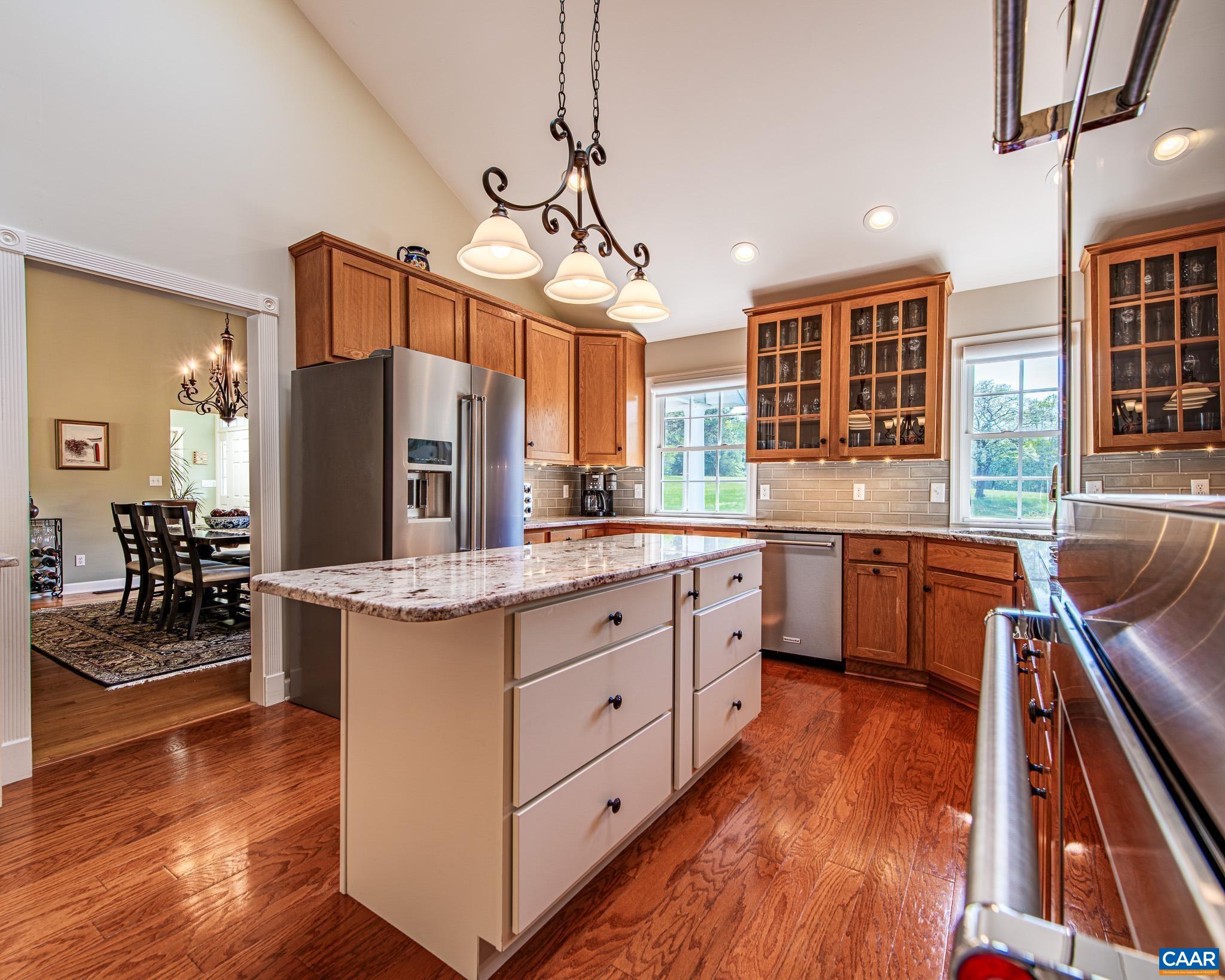 1089 Broken Island Road Palmyra, VA 22963 - Photo 26 of 74 a kitchen with kitchen island granite countertop wooden floors and white cabinets