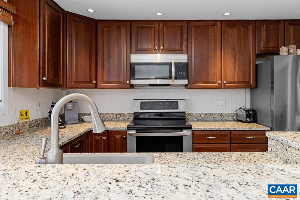 105 Eagles Court Wintergreen, VA 22967 - Photo 11 of 47 a kitchen with granite countertop a stove and a wooden cabinets