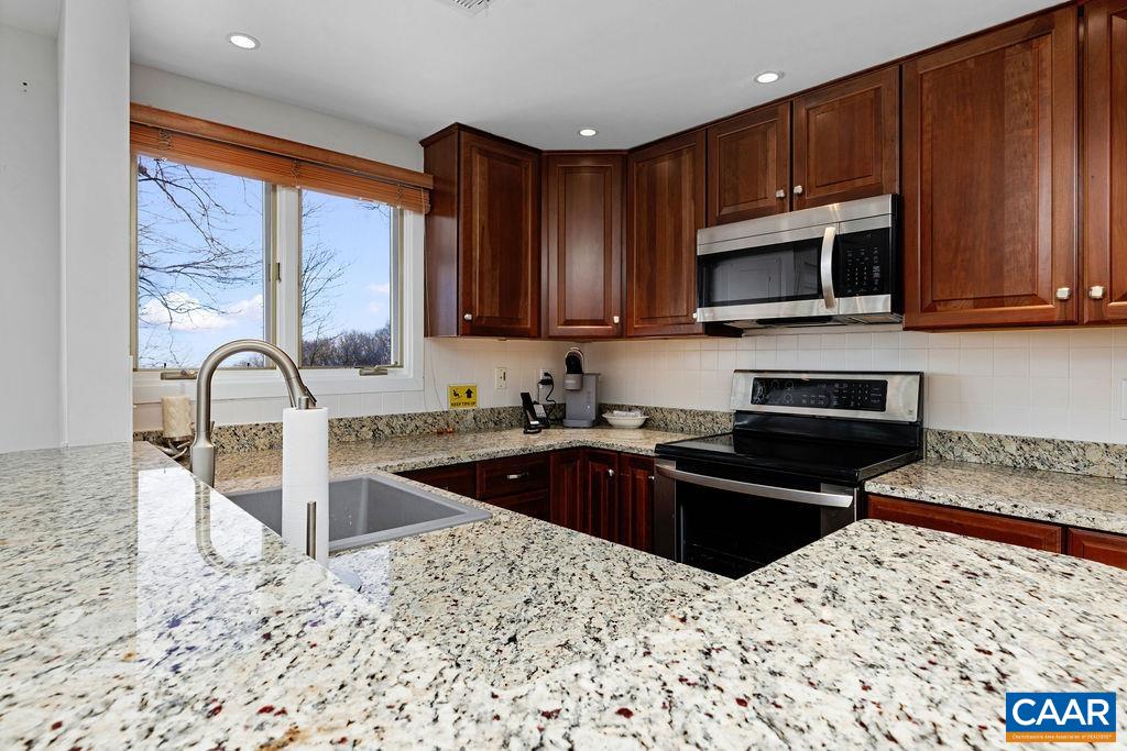 105 Eagles Court Wintergreen, VA 22967 - Photo 13 of 47 a kitchen with stainless steel appliances granite countertop a stove a sink dishwasher a refrigerator and cabinets with wooden floor