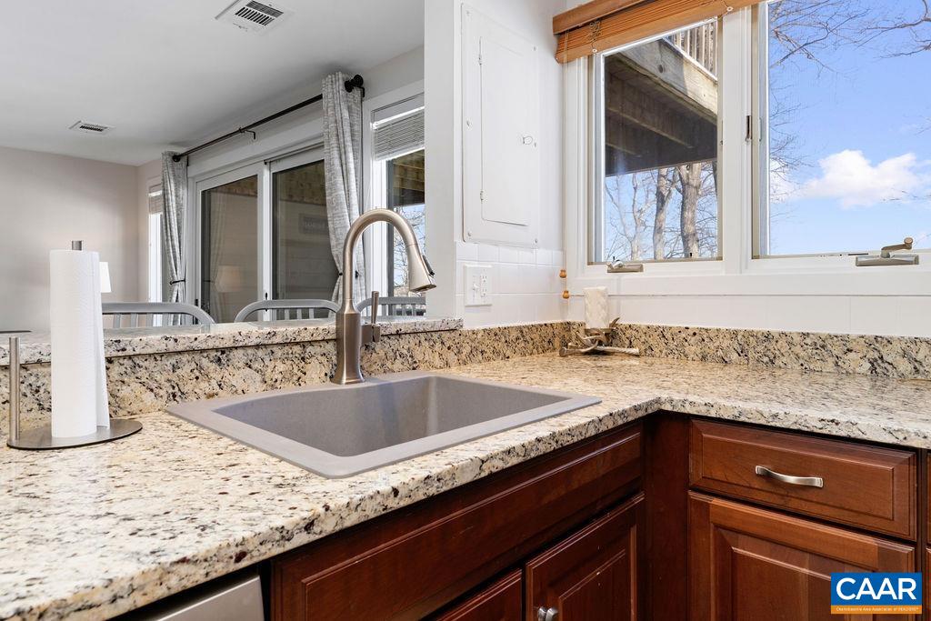105 Eagles Court Wintergreen, VA 22967 - Photo 14 of 47 a kitchen with granite countertop a sink and a wooden cabinets