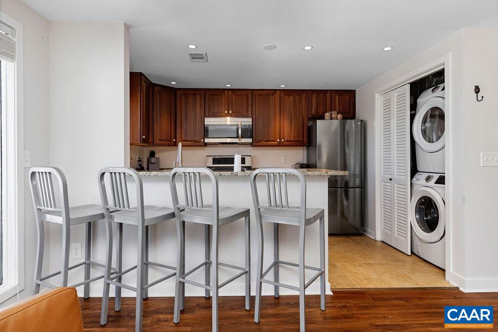 105 Eagles Court Wintergreen, VA 22967 - Photo 9 of 47 a kitchen with stainless steel appliances granite countertop a refrigerator a stove a sink a dining table and chairs