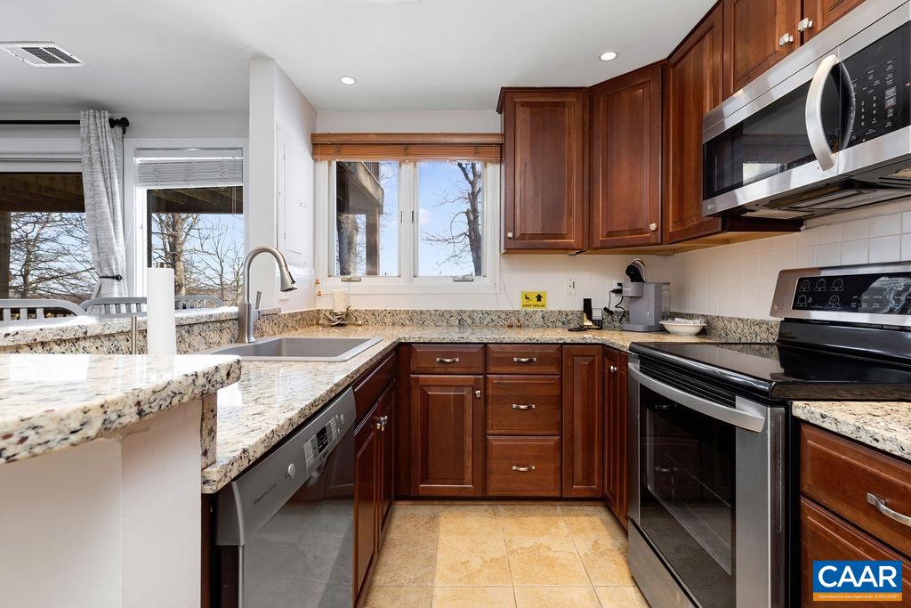 105 Eagles Court Wintergreen, VA 22967 - Photo 10 of 47 a kitchen with stainless steel appliances granite countertop wooden cabinets a stove top oven a sink and dishwasher