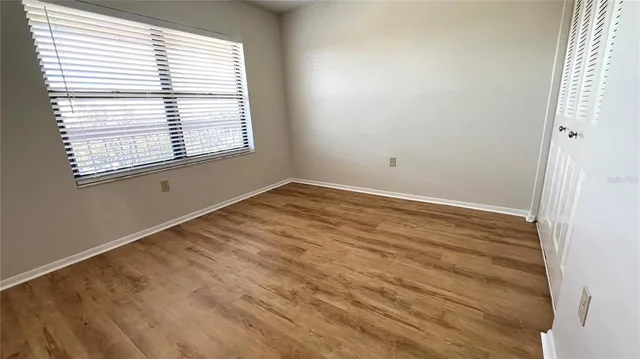 an empty room with wooden floor and entrance