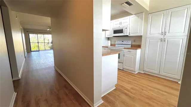 a kitchen with stainless steel appliances white cabinets and white stove