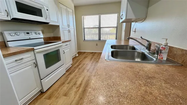 a kitchen with stainless steel appliances granite countertop a sink and a stove