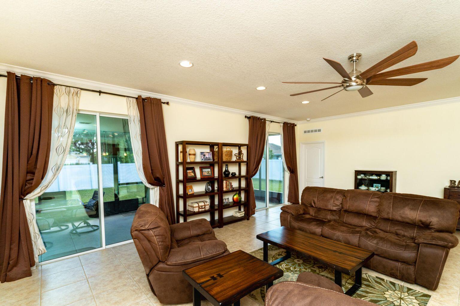 1026 Southwest Ingrassina Avenue Port St. Lucie, FL 34953 - Photo 11 of 20 a living room with furniture and a floor to ceiling window