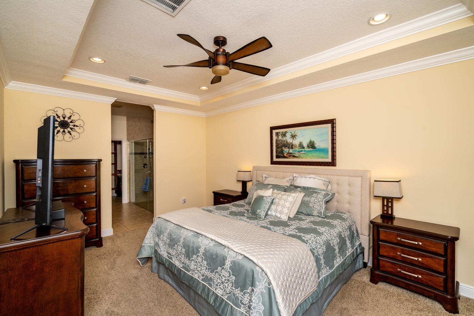 1026 Southwest Ingrassina Avenue Port St. Lucie, FL 34953 - Photo 13 of 20 a bedroom with a bed and a chandelier